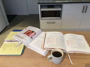 Cookbooks and coffee spread out on a table
